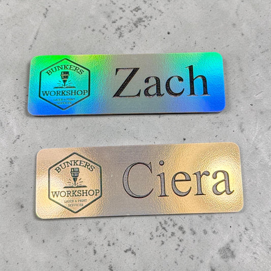Custom holographic name badge with UV printed logo, magnetic and pin back options, featuring a sleek, reflective design by Bunkers Workshop.
